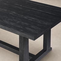 Landsbury Dining Table made of black pine featuring a textured, modern finish.