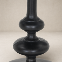 Calder Matchstick Pedestal Table featuring a unique, sculptural black base design.