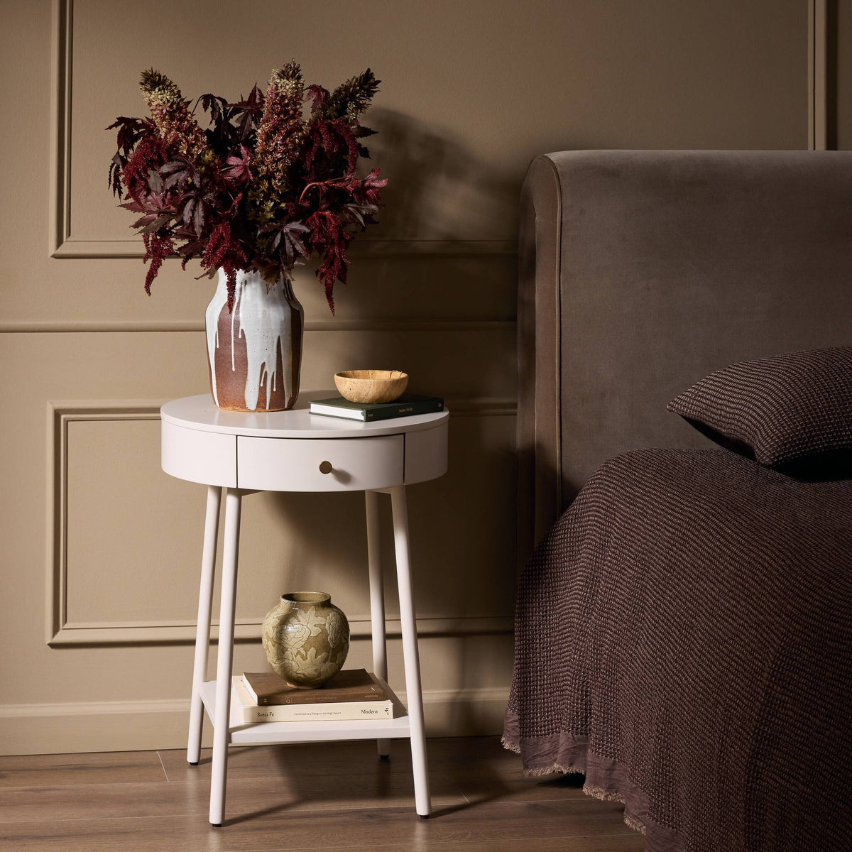 Finn Nightstand features a round design with a smooth finish and a single drawer.