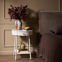 Finn Nightstand features a round design with a smooth finish and a single drawer.