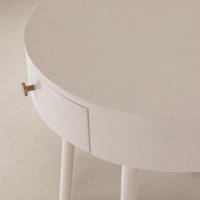 Finn Nightstand in soft pink features a round top and sleek legs with a gold handle.