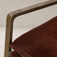 Close-up of the Sawyer Chair in Surrey Auburn, highlighting its plush cushion and sleek wooden armrest.