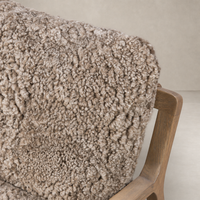 Taupe shearling upholstery of the Sawyer Chair showcases its soft, textured finish.