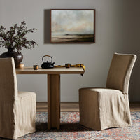 Sierra Slipcovered Dining Chair in Broadway Canvas with elegant, loose-fit design at a dining table.