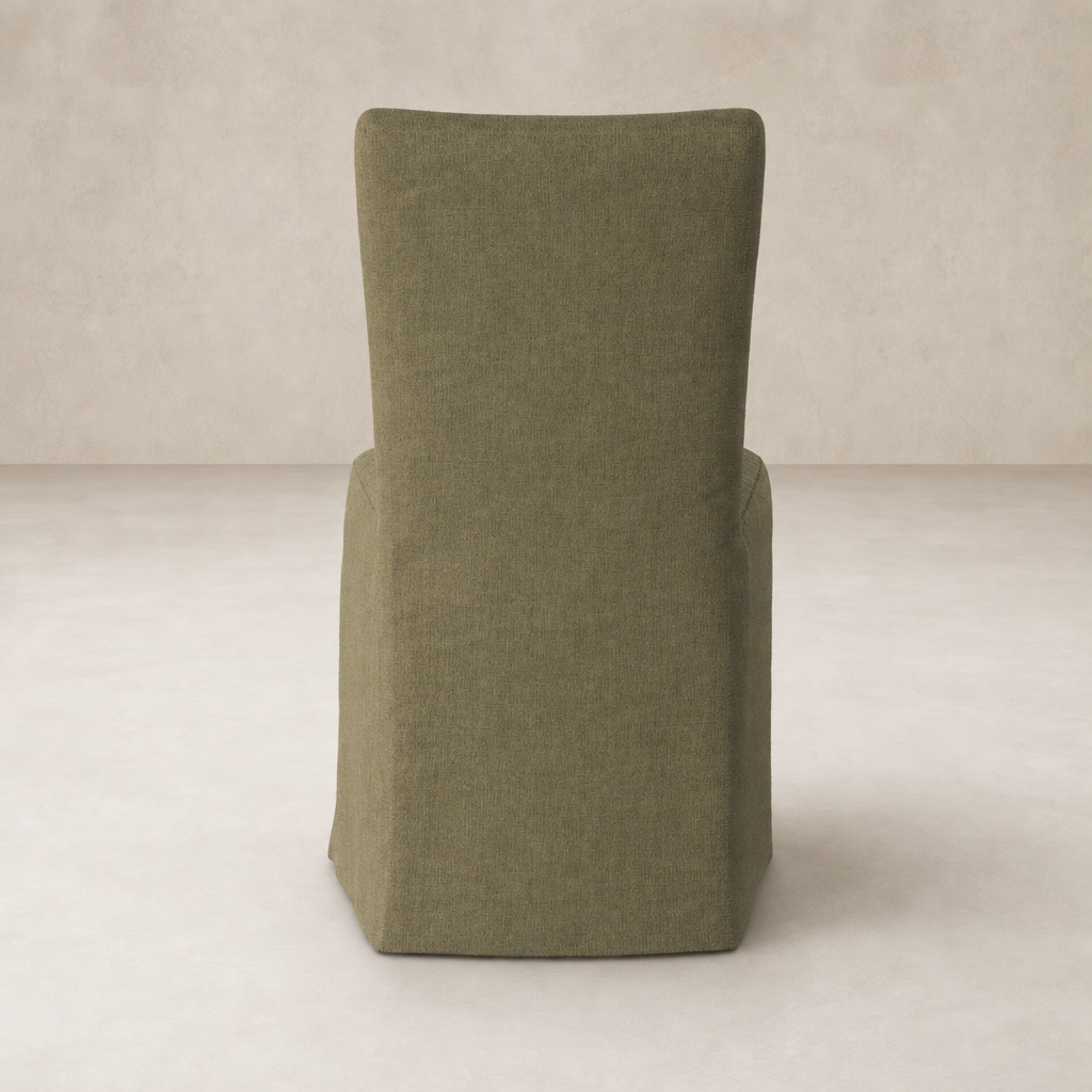 Sierra Slipcovered Dining Chair in Broadway Olive with a sleek, modern silhouette.