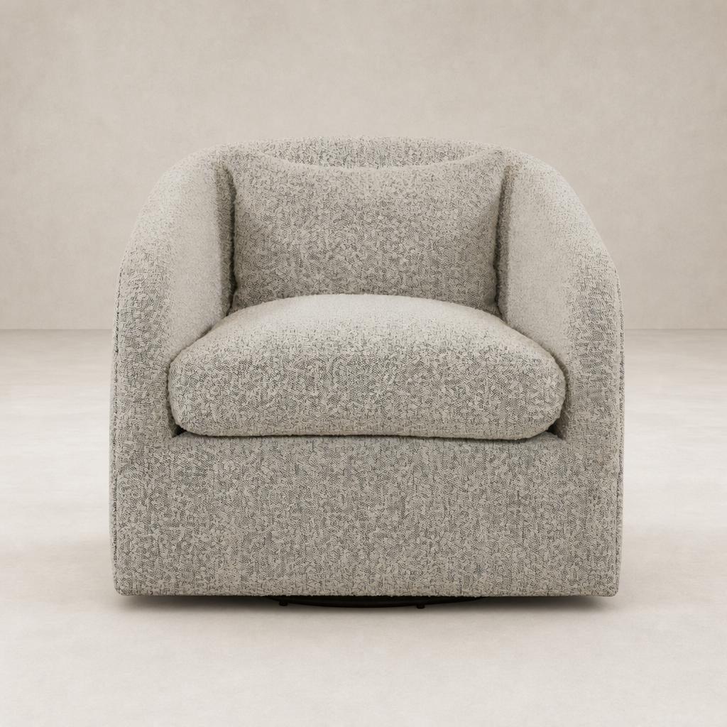 Magnolia Swivel Chair in Knoll Domino fabric features a cozy, curved design with plush cushions.