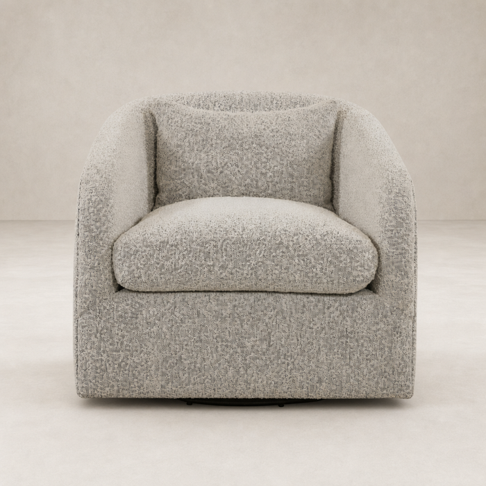 Magnolia Swivel Chair in Knoll Domino fabric features a cozy, curved design with plush cushions.