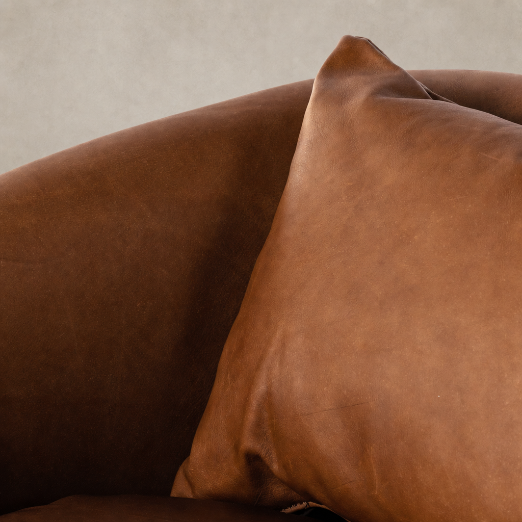 Close-up of Magnolia Swivel Chair in Heirloom Sienna, showcasing soft leather texture and cushion.
