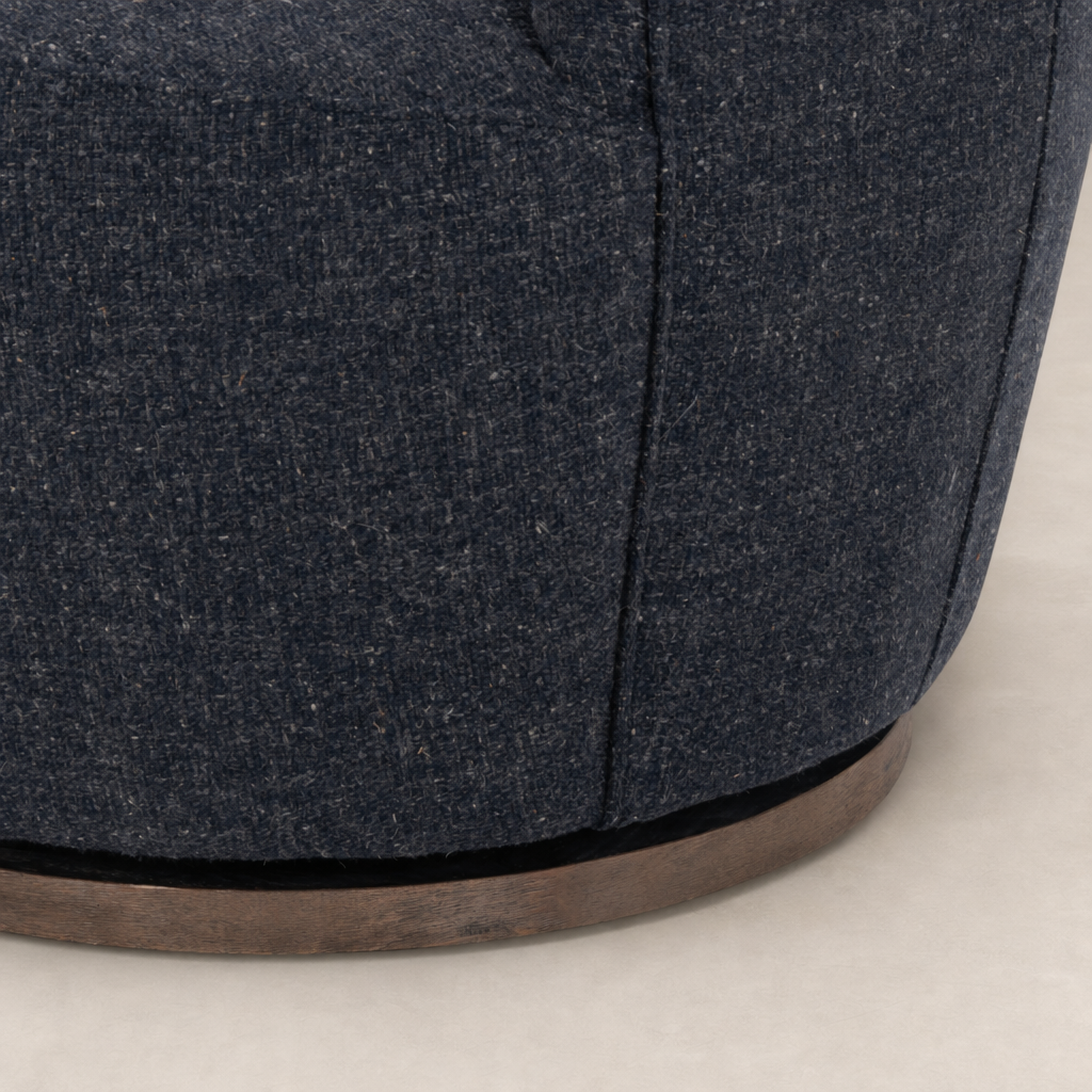 Close-up of the Soliel Swivel Chair in Thames Slate with textured fabric and wooden base.