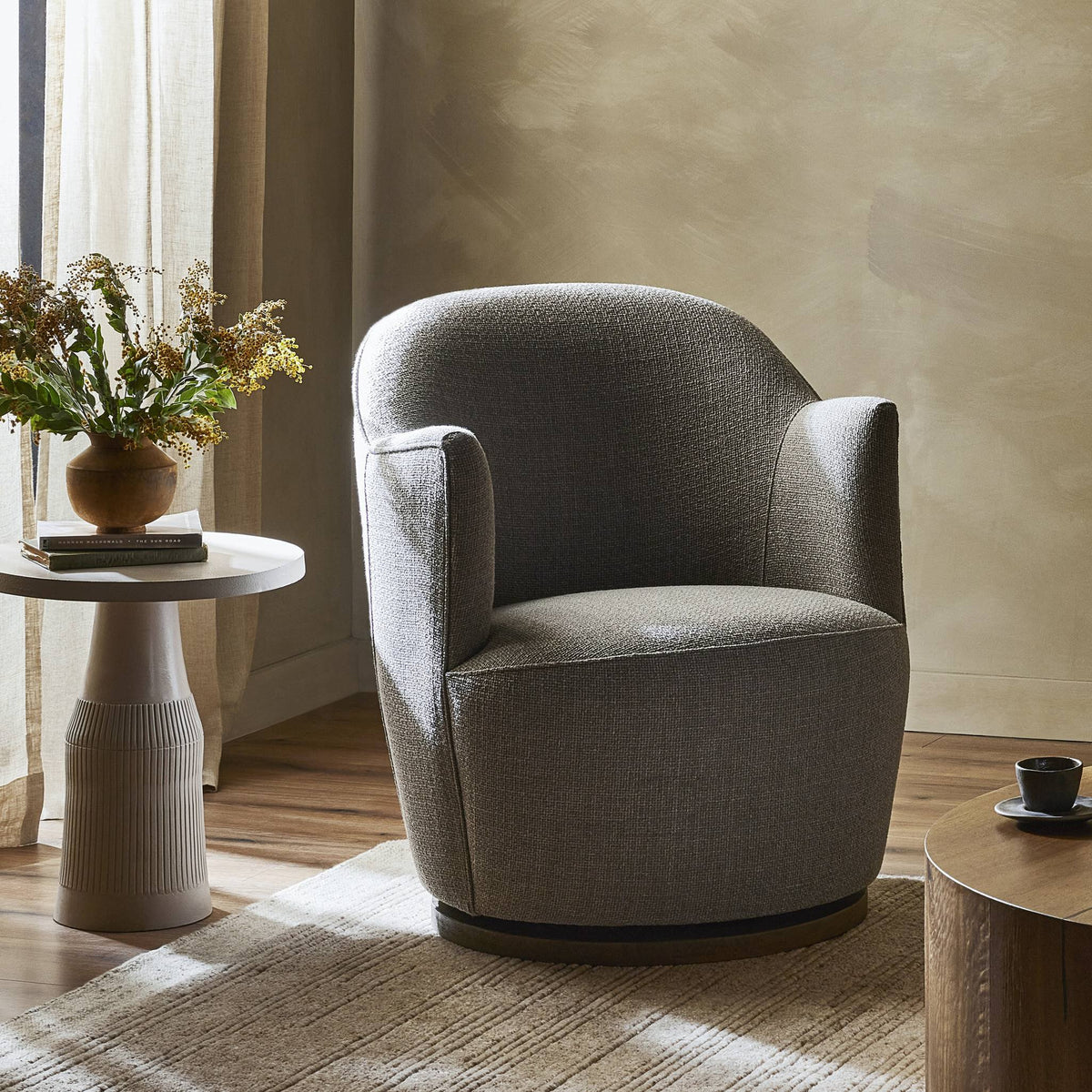 Soliel Swivel Chair in Gibson Silver, featuring a rounded design and textured upholstery.