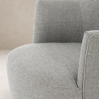Close-up of Soliel Swivel Chair in Gibson Silver, showcasing textured fabric and curved design.