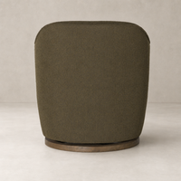 Soliel Swivel Chair in Fiqa Boucle Olive featuring a rounded back design and wooden base.