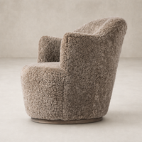 Taupe shearling Soliel swivel chair with a curved design and plush texture.