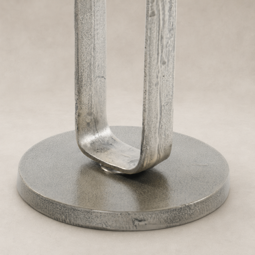 Rowan End Table featuring a sleek, brushed metal base and round, textured top.