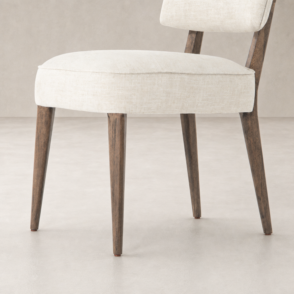 Orson Dining Chair in Cambric Ivory features a sleek design with elegant wooden legs.