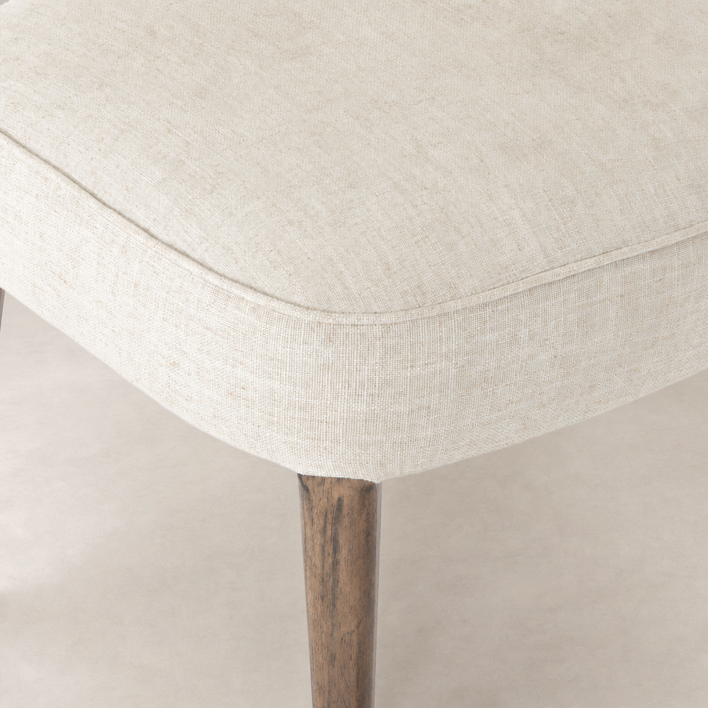 Orson Dining Chair in Cambric Ivory, showcasing a textured fabric seat and wooden legs.