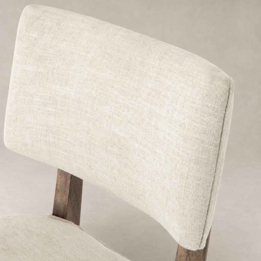 Close-up of the Orson Dining Chair in Cambric Ivory showcasing its textured fabric upholstery.