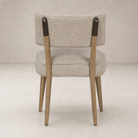 Orson Dining Chair in Mortensen Linen with a rounded back and wooden legs.
