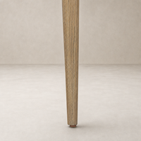 Mortensen Linen Orson Dining Chair showcasing a tapered wooden leg with natural finish.