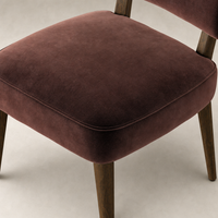 Orson Dining Chair in Surrey Plum with soft, plush upholstery and wooden legs.