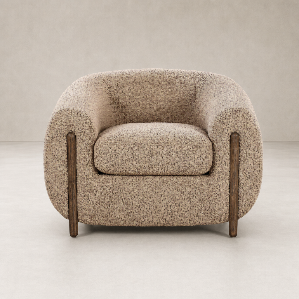 Clover Chair in Sheepskin Camel featuring rounded arms and polished wooden legs.