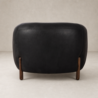 Curvy Clover Chair in heirloom black leather with wooden legs, showcased from the back.