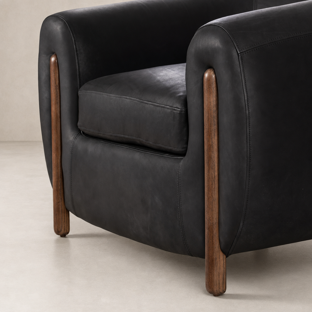 Clover Chair in heirloom black with wooden legs and plush cushioning details.