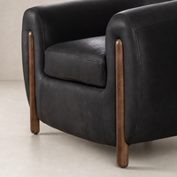 Clover Chair in heirloom black with wooden legs and plush cushioning details.