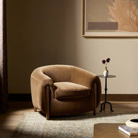 Clover Chair in Surrey Ochre featuring a rounded design and plush upholstery.