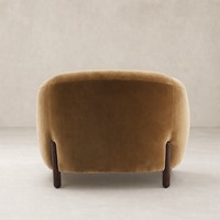 Clover Chair in Surrey Ochre featuring a smooth, rounded back and wooden legs.