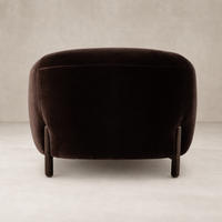 Clover Chair in Surrey Cocoa featuring a rounded back and wooden legs.