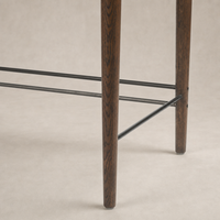 Detail of Quince Desk's dark toasted oak legs and modern metal support.