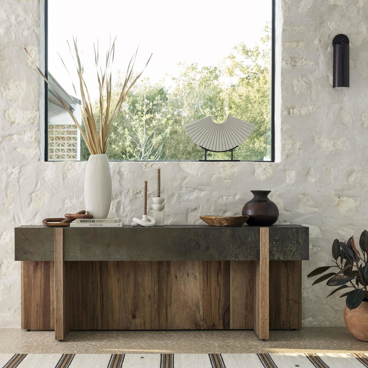 Rustic Oak Beckett Console Table with a sleek top and textured wood base, styled in a cozy room.