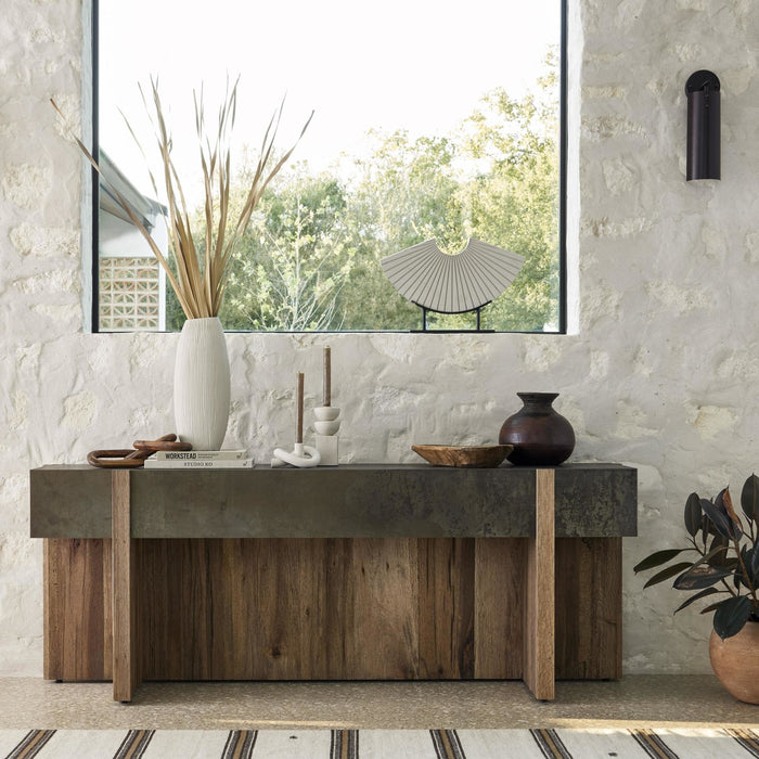 Rustic Oak Beckett Console Table with a sleek top and textured wood base, styled in a cozy room.