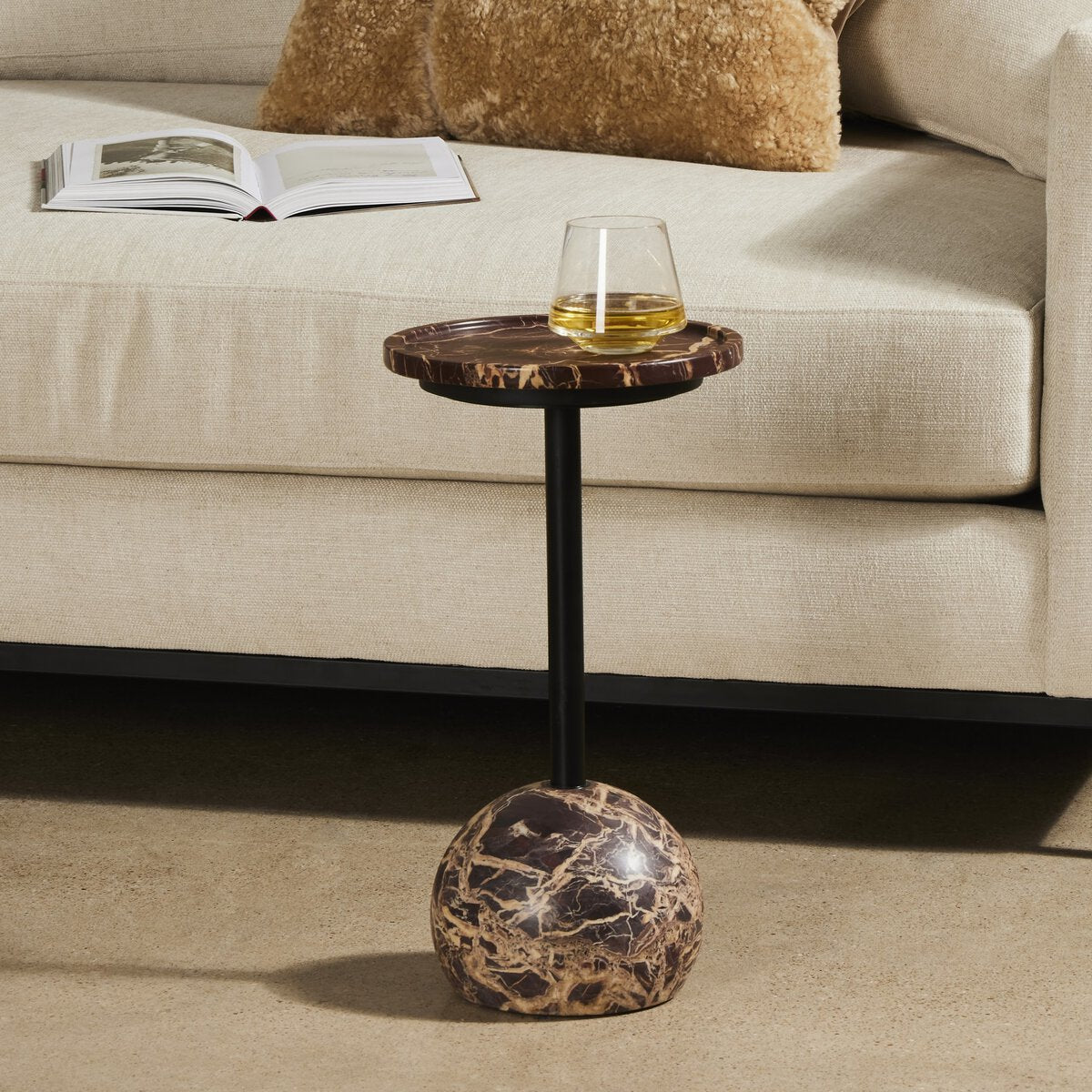 Close-up of the Wren Accent Table featuring a round marble top and a sleek black metal base.