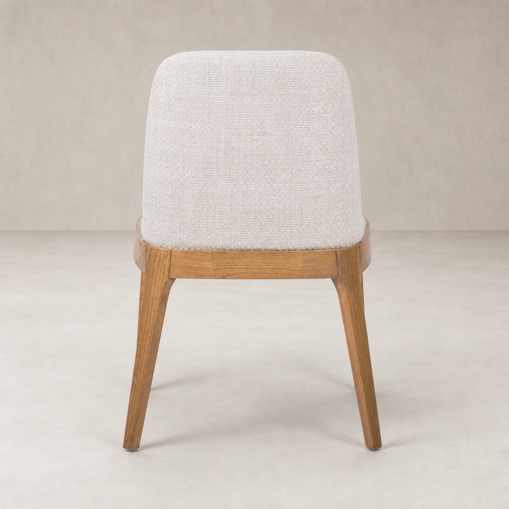 Rhys Armless Dining Chair in Gibson Wheat with a soft fabric finish and wooden legs.