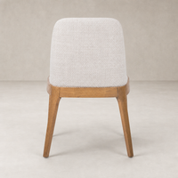 Rhys Armless Dining Chair in Gibson Wheat with a soft fabric finish and wooden legs.