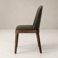 Rhys Armless Dining Chair in Bilton Olive with a sleek, modern silhouette and wood legs.