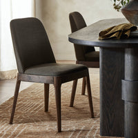 Rhys Armless Dining Chair in Bilton Olive with a sleek design and wooden legs.