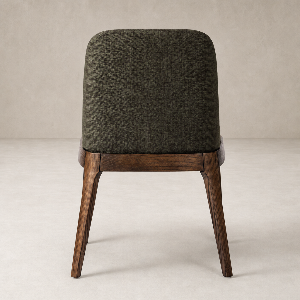 Rhys Armless Dining Chair in Bilton Olive with a curved back and wooden legs.