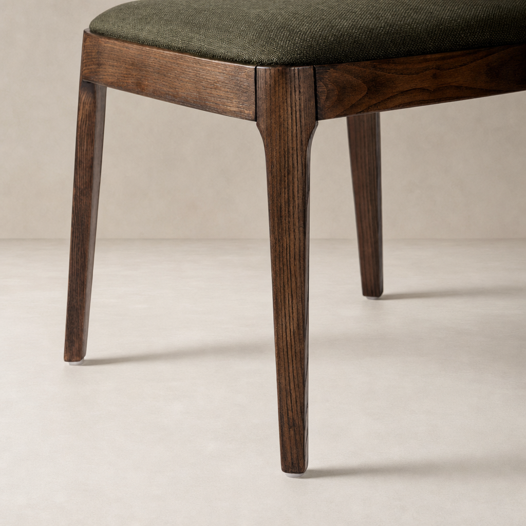Rhys Armless Dining Chair in Bilton Olive with dark wooden legs and textured upholstery.