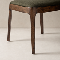 Rhys Armless Dining Chair in Bilton Olive with dark wooden legs and textured upholstery.
