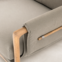 Mykonos Chair in Villa Olive featuring sleek design and wooden armrest detail.