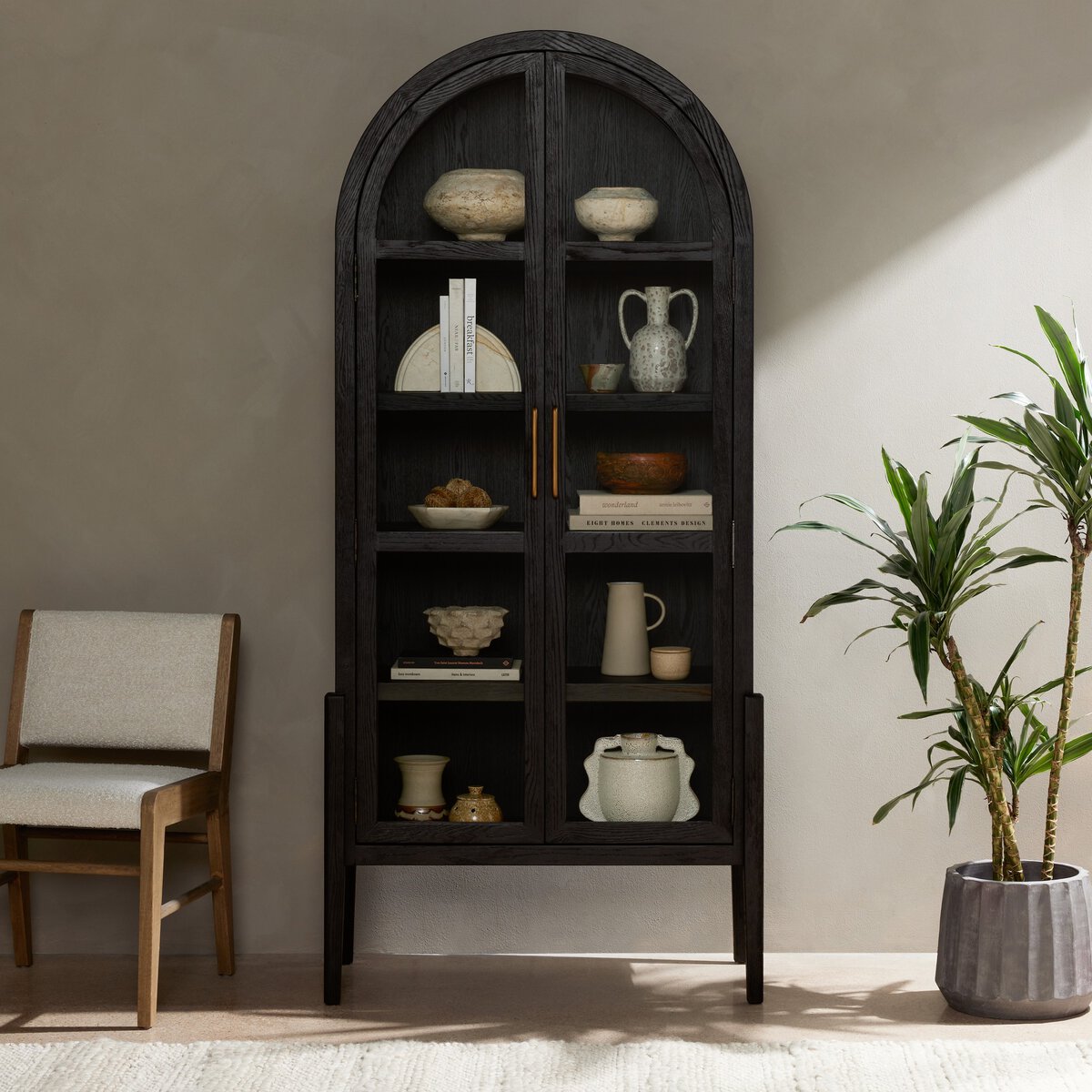 Front view of the Ember Display Cabinet in a modern setting, showcasing its elegant arch design and dark finish.