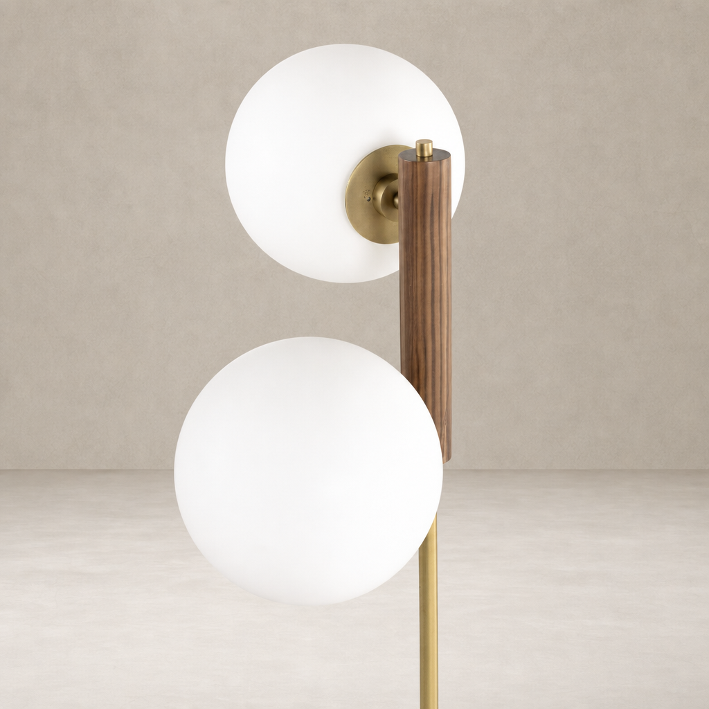 Aged brass floor lamp with two white glass globes and wooden accent.