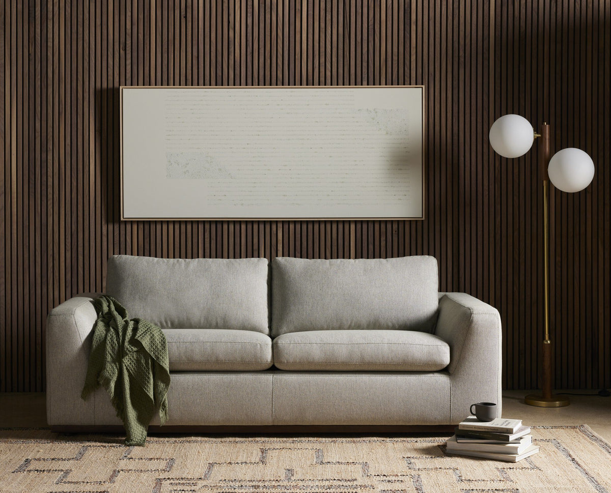 Aged brass floor lamp with spherical white shades complementing a modern sofa.