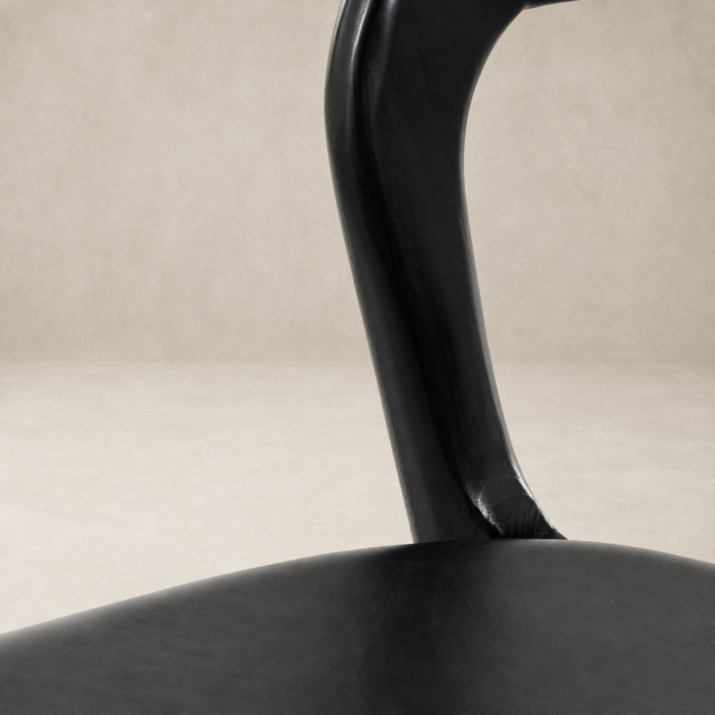 Close-up of Amato Dining Chair in Sonoma Black, showcasing its sleek, curved leg design.