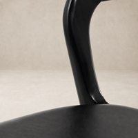 Close-up of Amato Dining Chair in Sonoma Black, showcasing its sleek, curved leg design.