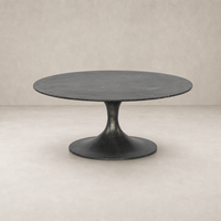 Sabine Round Coffee Table in raw black with a sleek, contemporary design and pedestal base.