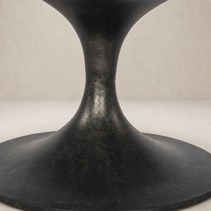Elegant Sabine Round Coffee Table in raw black with a sleek, sculptural base.